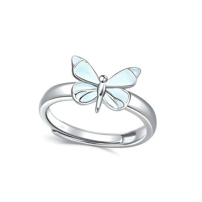 Silver ring with a dragonfly-shaped gem on a white background