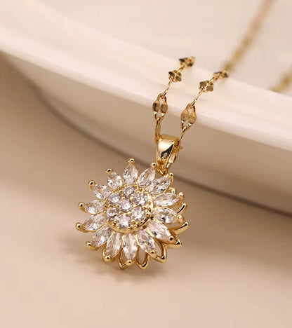 Gold necklace with a sunflower-shaped pendant on a beige background